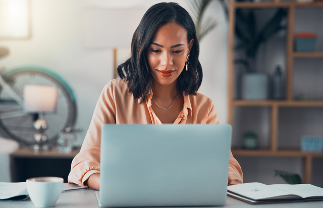 Woman in yellow shirt looking into GICs on laptop